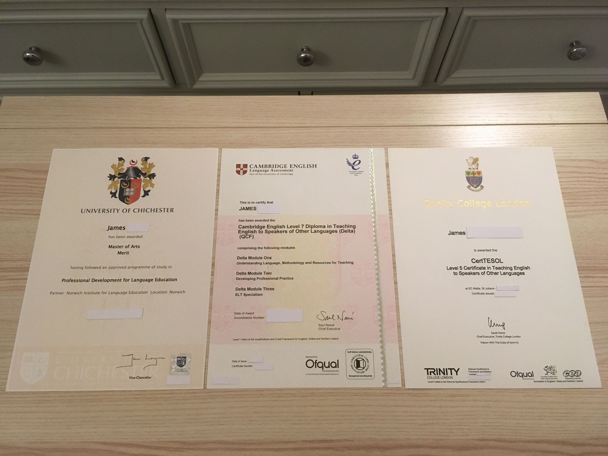 The three original qualifications mentioned above laid next to each other on a table with the sensitive information covered.